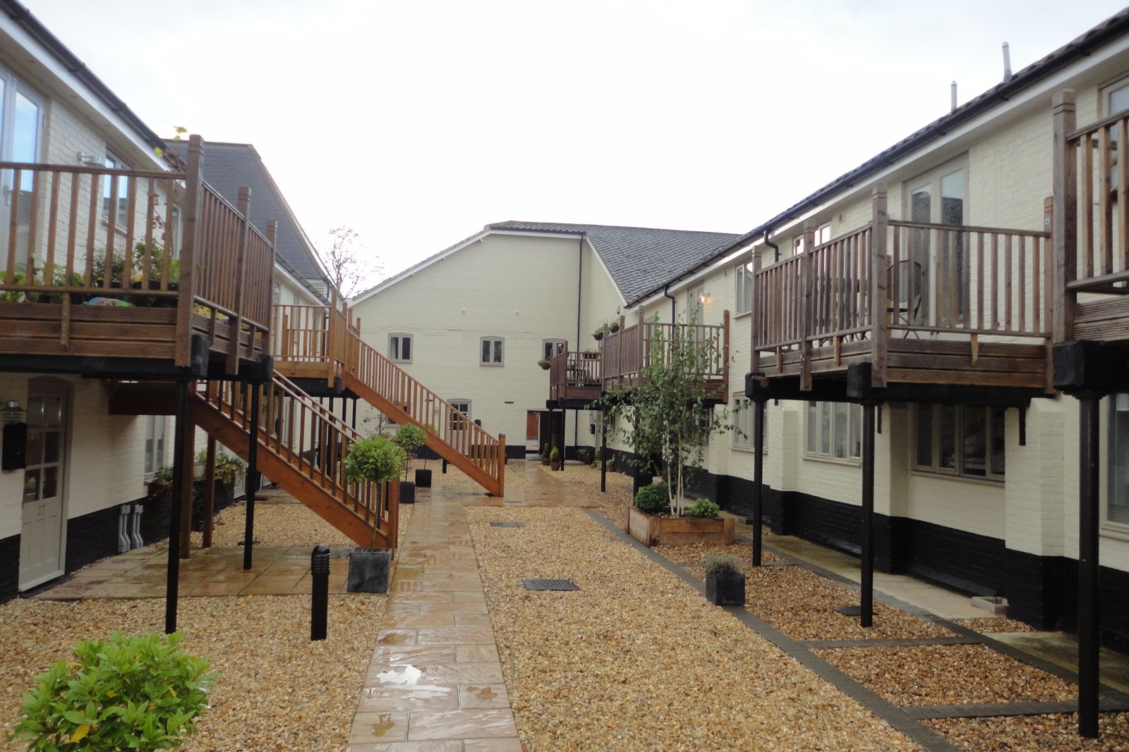 Landscaped courtyard of the converted maltings with timber balconies