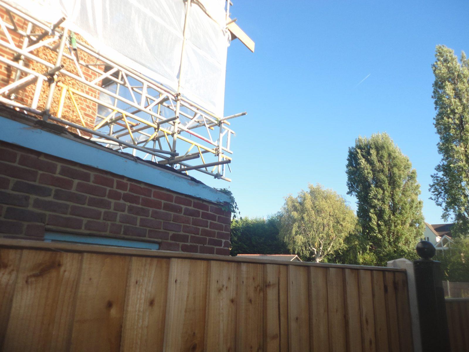 Scaffolding to the building owner's house in Loughton seen over the boundary fence from a neighbouring property