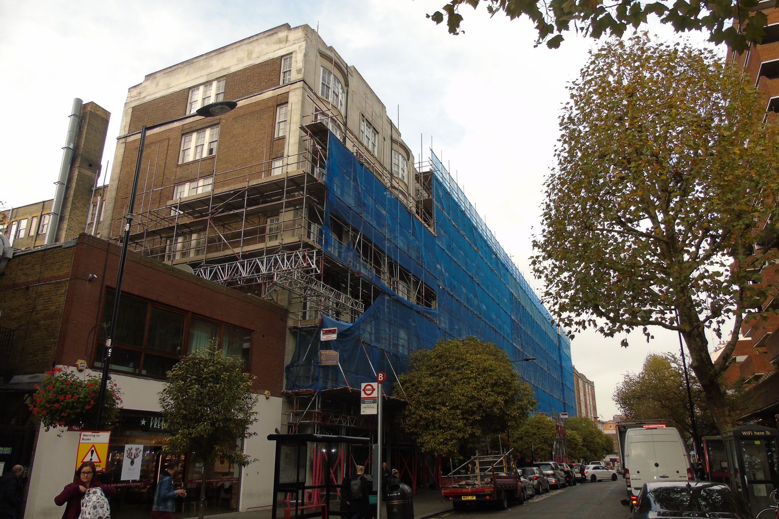 Scaffolded 1920s mansion block over shops in Westminster during external repairs